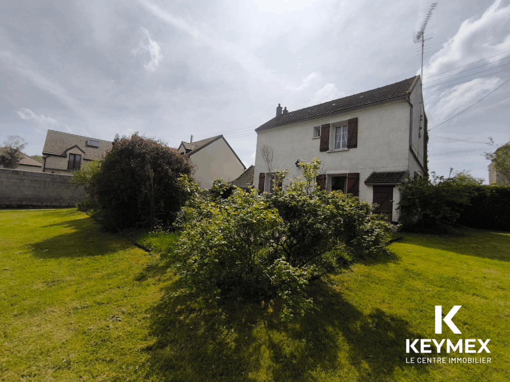 Maison avec jardin et ciel nuageux
